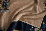 Textured beige field of a vintage Peking rug with deep blue floral border.