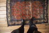 Vintage Malayer rug displaying allover blue and red floral motifs with varied pile.