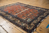 Vintage Malayer rug field showing red ground, blue cintamani-like motifs, and navy border.