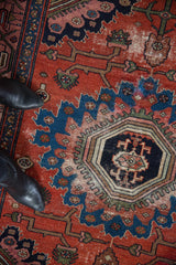 Vintage Malayer rug: geometric medallion detail, brick red field, and mostly even wear.