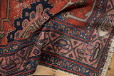 Vintage Malayer rug's classic Serbend border, meandering vines, and tattered fringe.