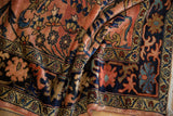 Lush pile of a vintage Persian Lilihan carpet with navy floral border and rose field blossoms.