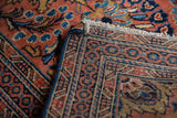 Original fringe and hand-knotted back of a vintage Dargezine rug, brick red and blue.