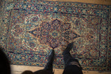 Antique Lavar Kerman rug's curvilinear floral pattern in blue, ivory, and cochineal red.