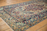 Curvilinear floral design on navy blue arabesque main border of antique Lavar Kerman rug.