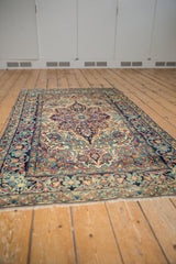 Curvilinear floral field and arabesque border in navy blue, cochineal red, and ivory.
