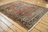 Vintage Arak rug detail: dusty rose field, floral blossoms, navy arabesque palmette border.
