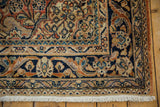 Vintage Arak rug corner, navy blue main border with terracotta, beige arabesque, white fringe.