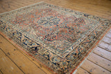 Vintage Arak rug corner with navy arabesque border and dusty rose floral field.