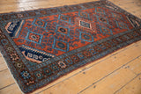 Persian Mehreban rug: floral border detail, brick red field with blue hook and latch motifs.