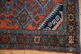Vintage Mehreban rug corner with a dark floral main border and original side selvage.