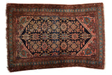 Vintage Lilihan rug, navy blue field, intricate floral Veramin design, rust-blush borders.