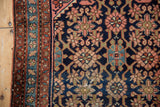 Vintage Lilihan rug close: intricate navy field, blush florals, rust border, foundation wear.