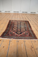 Vintage Lilihan rug corner displaying navy Veramin floral field, chestnut border, and original fringe.