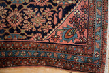 Vintage Lilihan rug corner showcases blush starburst main border and teal meandering floral minor border.