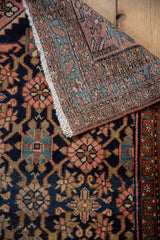 Vintage Lilihan rug detail showing floral field and starburst border in navy, blush, and rust.