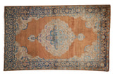 Vintage distressed Kerman rug with ornate European Rococo medallion and sandalwood field.