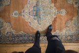 Ornate Rococo medallion detail on vintage distressed Kerman rug with blue and ivory.