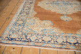 Vintage distressed Kerman rug corner: abrashed sandalwood field, sky blue European Rococo spandrel, navy border.