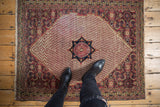 Vintage Khorassan rug showing unusual navy charcoal medallion, cochineal red boteh, and Herati spandrel.