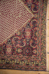 Vintage Khorassan rug showing dog-eared corner, Herati motif, and red boteh field.
