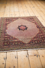 Vintage Khorassan rug corner with ivory fringe and a red, navy, ivory floral border.