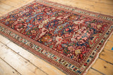 Antique Seichor Kuba rug corner with geometric Dragon motifs, intricate border, and tattered fringe.