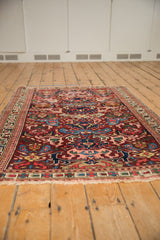 Geometric bursting floral arabesques, wine red, and fringed edge of antique Kuba rug.
