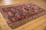 Tattered side edge, geometric Caucasian style borders, and vibrant motifs of the antique Kuba rug.