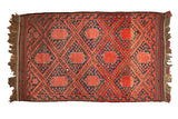 Vintage Beshir rug with madder red gul panels, navy blue speckled fields, and trellis diamonds.