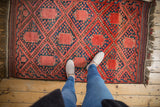Vintage Beshir rug showcasing madder red gul medallions within a navy blue speckled blossom field.