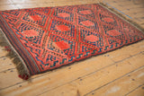Beshir rug end showcasing original plain weave fringe and madder red, navy geometric patterns.