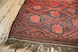 Vintage Beshir rug corner, madder red gul medallions, blue speckled blossoms, and fringe.