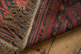 Fringed end of vintage Turkmen Beshir rug, showing striped plain weave and exposed foundation.