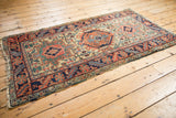 Corner detail of the vintage Heriz rug, showing serrated leaf border and fringed end tatter.