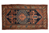 Vintage Mehreban rug with geometric copper and terra cotta medallion, deep navy field, and fish motifs. 3'4
