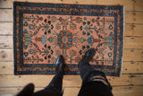 Intricate curvilinear floral motifs throughout the dusty rose vintage Persian Lilihan rug.