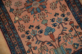 Intricate detail of vintage Lilihan rug, dusty rose field with unique blue, red, beige floral motifs.