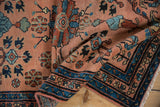Corner of vintage Lilihan rug: blue and black patterned border, dusty rose field with floral designs.