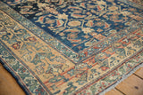 Distressed Lilihan rug featuring Herati motif, navy field, and wide ivory floral border.