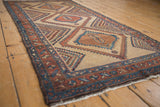 Side view of a collector Serab rug showing its hand-knotted texture and serrated diamond medallions.