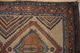 Detail of an antique Serab rug's serrated medallion and intricate multi-color checkered pattern.