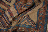 Textured camel hair pile of an antique Serab rug showing intricate checkered motifs.