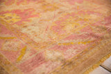 Distressed angora wool pile texture of the Oushak rug, showing muted raspberry and saffron tones.