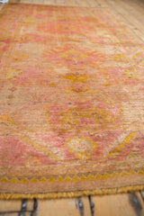 Distressed angora wool pile on vintage Oushak rug, showcasing faded mauve and saffron patterns.