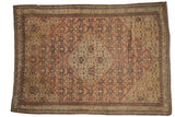 Antique Persian Senneh rug with a distressed Herati medallion in rust, ivory, and navy blue.