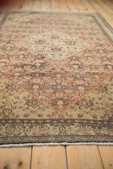 Angled view highlighting the time-softened tones and intricate Herati pattern of an antique Senneh rug.