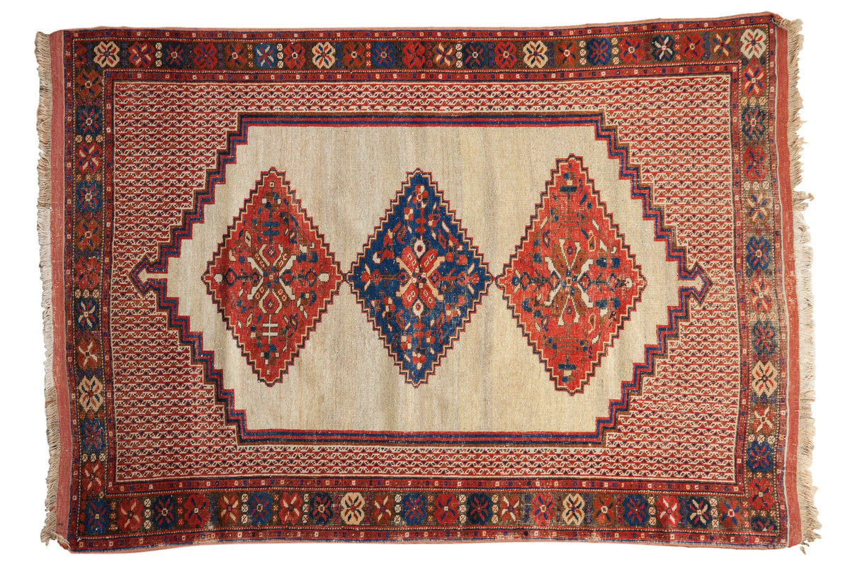 Antique Afshar rug with a triple center medallion in red and sapphire blue set on an unusual ivory ground.