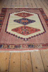 A low-angle view of an antique Afshar rug showcases its triple-medallion design and full length.