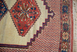 Corner of an antique Afshar rug showing its multi-banded floral border and original ivory fringe.